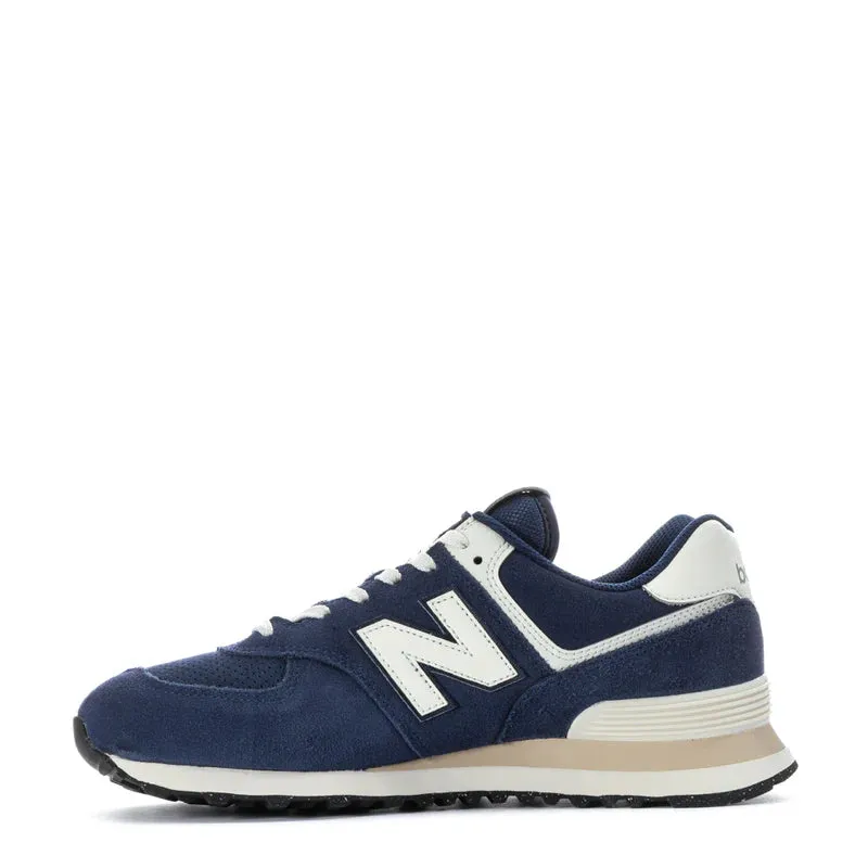 New Balance Men's 574 Sneaker in Navy with Sea Salt running on snow shoes